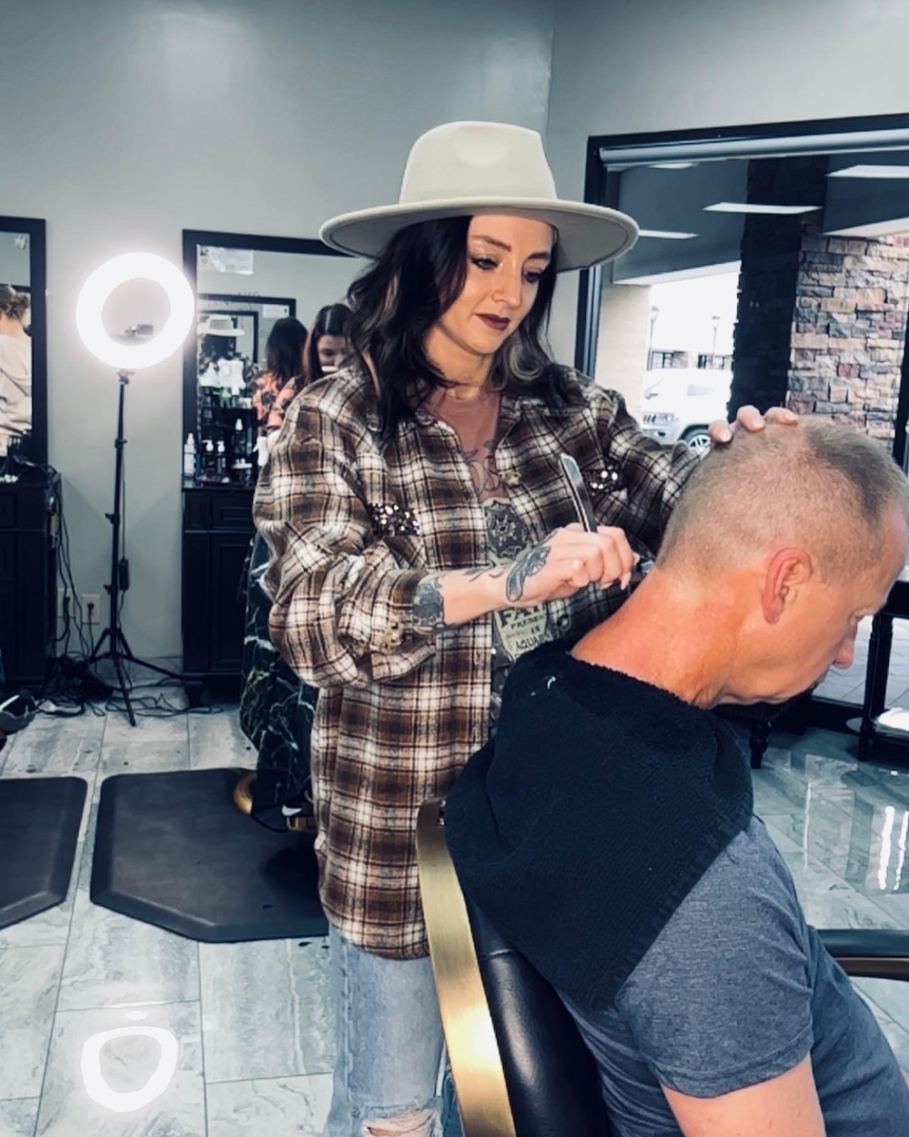 Rachel Trammell finishing a client's neckline with a straight razor